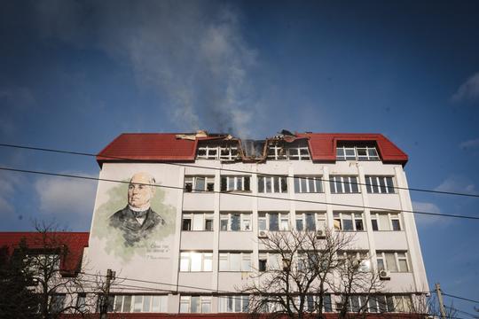 У червоному даху пошкодженого будинку утворилася вибоїна. Під нею зображений портрет Харитоненка.