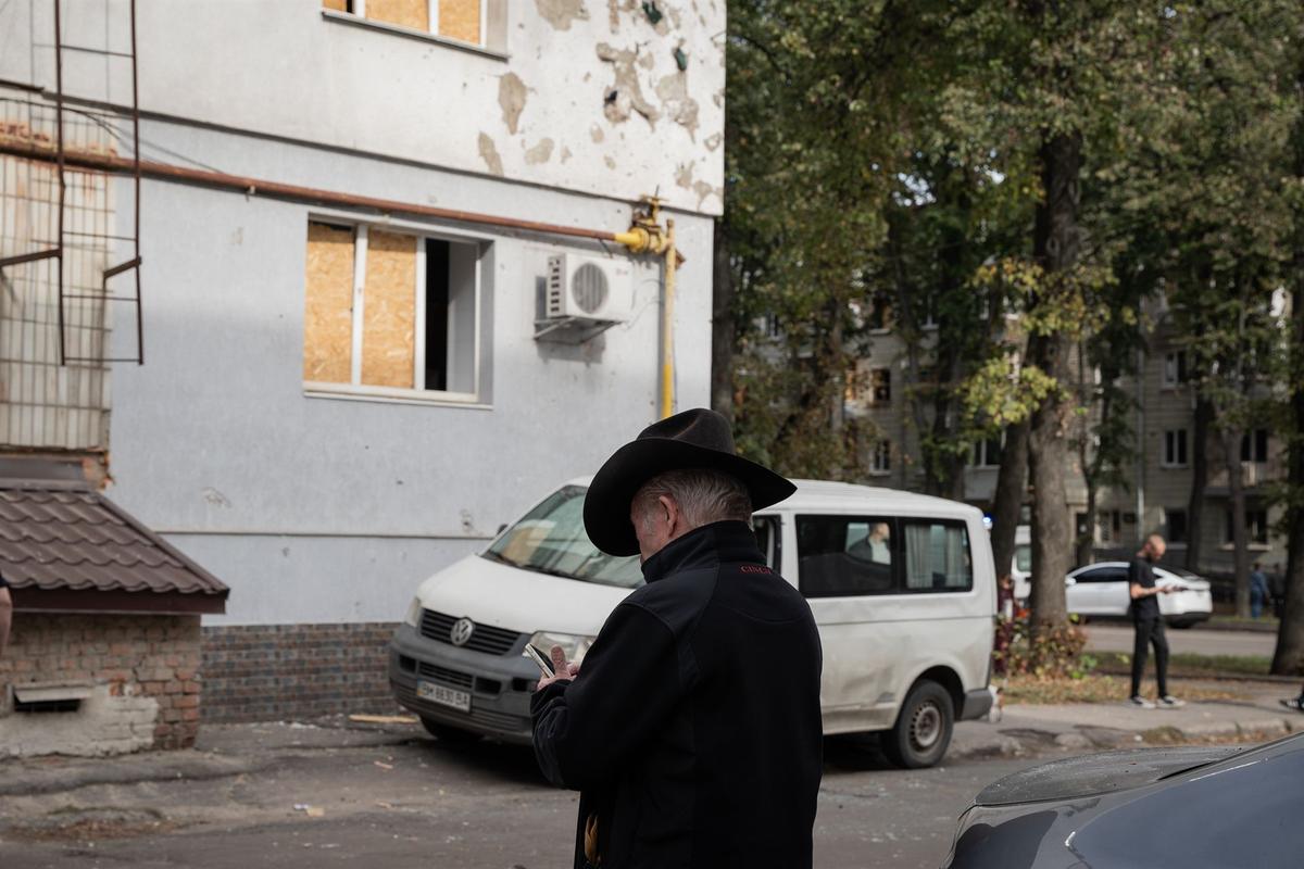Чоловік біля пошкодженого будинку в Сумах