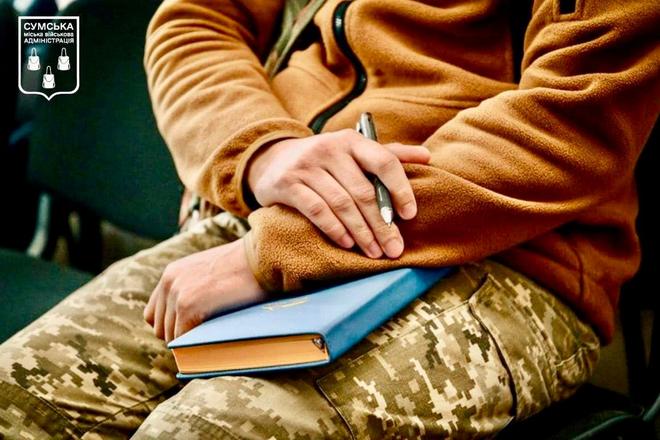 Військовий тримає книгу в руках