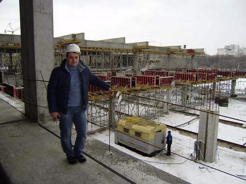 Керівник ТРЦ у касці перевіряє виконані роботи з будівництва