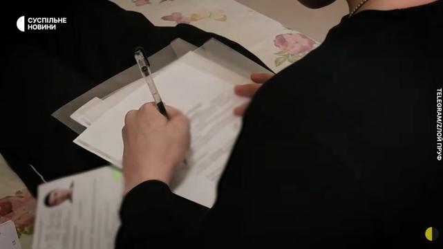 Чоловік підписує документ про отримання громадянства.