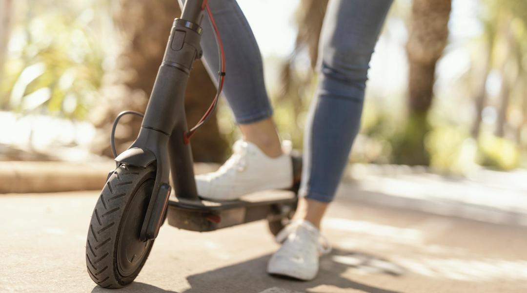 young woman rides electrical scooter city e1625741584575