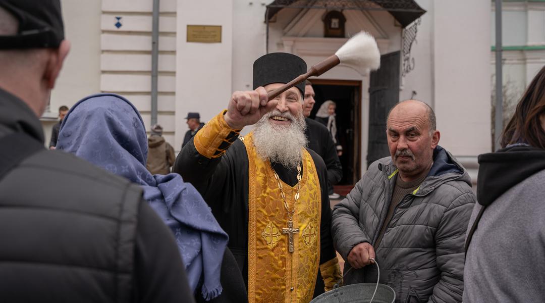 Панотець кропить фотографа у черзі