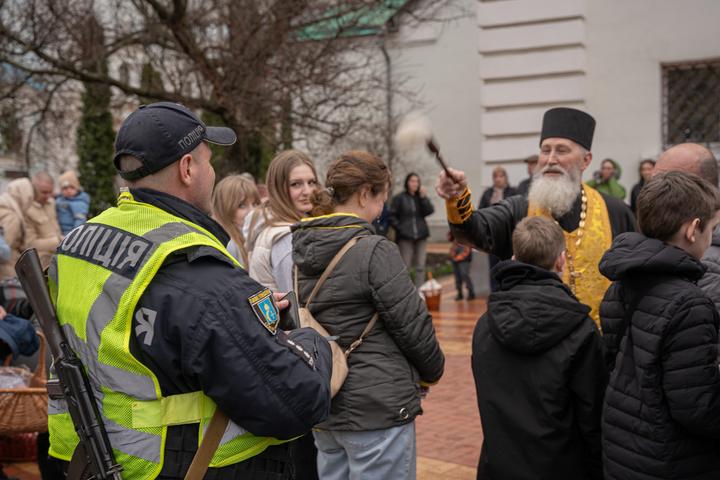 Батюшка кропить поліцейського і дякує за службу