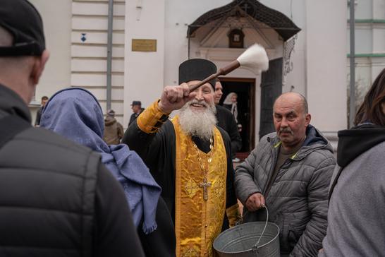 Панотець кропить фотографа у черзі