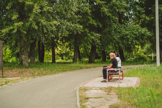 park sumy lito = люди сидять на лаві у Сумах