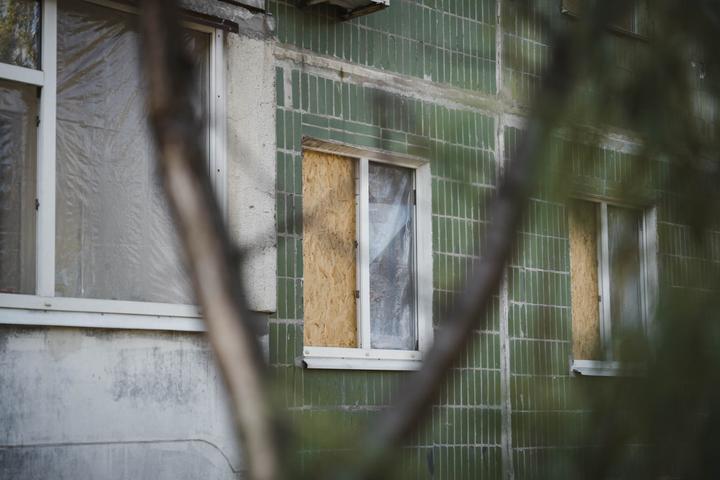 Пошкоджені вікна будинку на Героїв Крут Вікна багатоповерхівки на вулиці Суми, забиті ОСБ-плитами