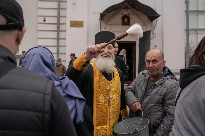 Панотець кропить фотографа у черзі