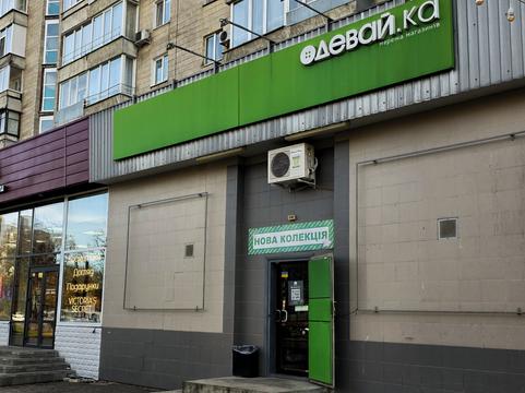 Вхід до магазину «Одевай.ка» у Сумах: зелена вивіска на фасаді багатоповерхівки, над дверима банер «Нова колекція»