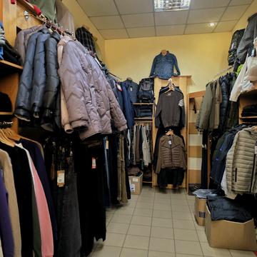Зала магазину «Одевай.ка» у Сумах: ряди курток і пуховиків, джинси, светри, на стійці манекен у джинсовій куртці