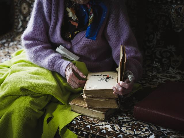 Марія Трохимівна гортає старенькі книги