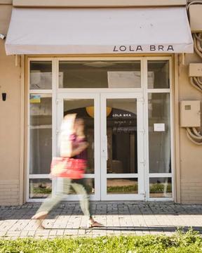 до шоуруму Lola Bra на провулку Монастирському в Сумах: білий навіс з назвою, скляні двері з графіком