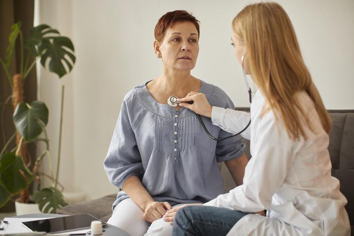 covid recovery center female doctor checking elder patient s heartbeat