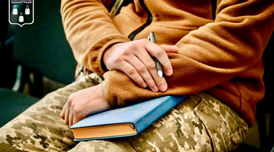 Військовий тримає книгу в руках