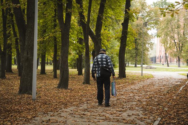 Літній чоловік в осінньому парку в Сумах