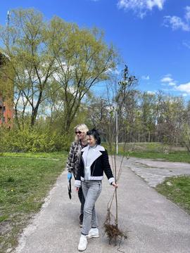 Жінка несе кущик у руках