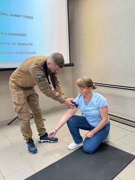 Інструктор з домедичкої допомоги показує, як накладати турнікет
