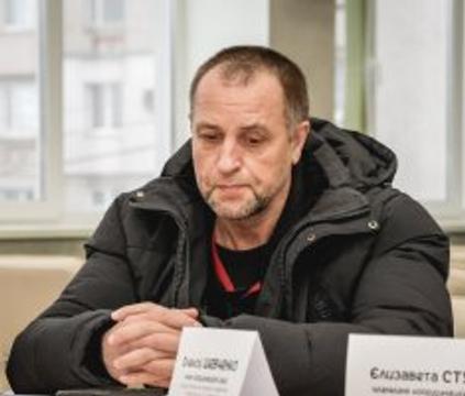 Депутат СМР вслухається й думає. На ньому - чорна куртка.