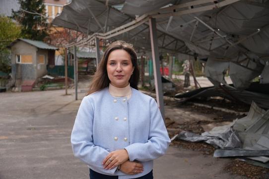 жінка стоїть на фоні стоянки