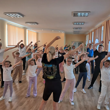 Вчителька на уроці фізкультури показує дітям вправи