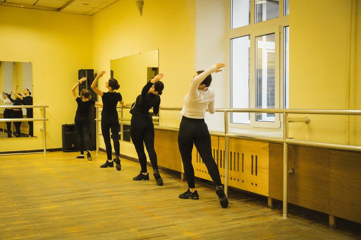 Розминка танцівниць біля станка на репетиції в Сумах